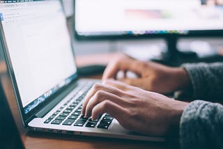 A student typing on his/her laptop.