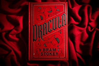 A red hardback copy of Dracular on red velvet.