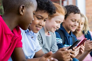 Five elementary school students on their phones.