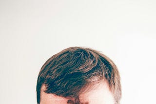 Tony Reali from ESPN has a giant black smudge on his forehead.