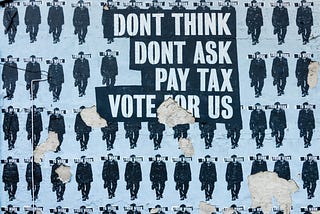 Blue and black street art that reads “don’t think don’t ask pay tax vote for us”