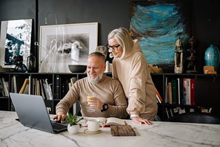 A man and woman looking at a laptop.