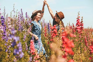 Two women in a field of flowers.