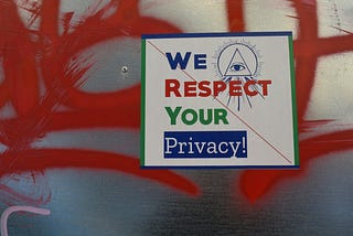 We respect your privacy sign over red graffiti.