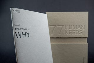 The image shows a book titled “The Power of Why”. The book is sitting on a table next to a cardboard box. The book is open to a page with the text “77 WEE PHUMAN”. The box has the text “The Power of WHY. 77HUMAN NEEDS”.
 
 The image is simple and minimalist, with a focus on the book and the text. The colors are muted, with the dominant colors being white, black, and brown. The overall impression is one of calm and introspection.