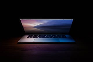 half-open computer surrounded by darkness