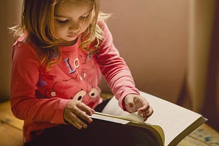 Childhood Photography, a young girl reading a book.