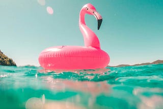 A blowup flamingo floating in the water.