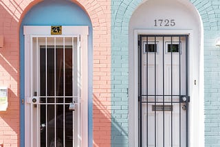two almost identical front doors to two almost identical brick houses