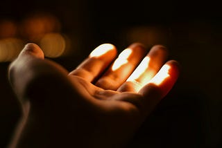 Hand in the shadows wth the sun shining on a part of it.