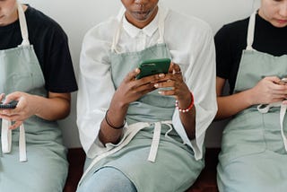 Three employees on a break watching in their phones.