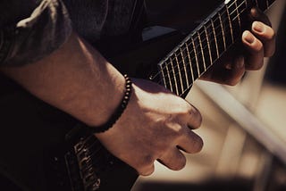 A photo of a guitarist playing a guitar.