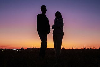 Silhouetted couple standing apart at sunset — visual metaphor for emotional distance in relationships when seeking fulfillment only God can provide, illustrating the key concept from ‘Why Your Spouse Can’t Be Your Messiah’ article about marriage expectations and spiritual needs