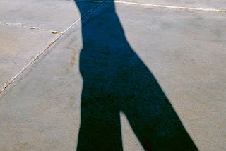 Silhouette of a person walking on a concrete.