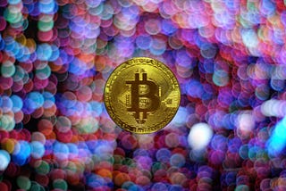 A mock up of a bitcoin gold coin with rainbow lens flares for a background