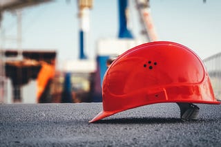A safety hard-hat placed in front of a construction site.