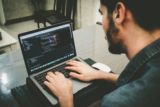 Man coding on laptop