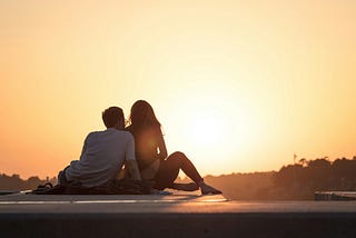 Couple sitting together, enjoying the sunset,