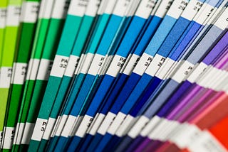 A collection of Pantone color swatches ranging from green to blue, to purple, to red.