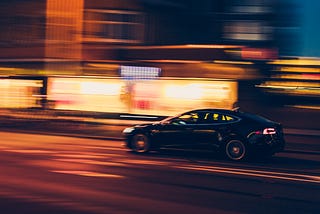 A car driving at a fast speed with background blurred