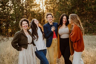 A group of women laughing together in a field