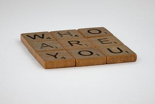 Scrabble pieces that says WHO ARE YOU?