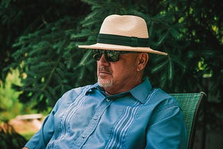 Man in Panama hat and sunglasses relaxing in a chair