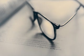 Glasses blurred on top of an opened book.