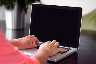 Person sitting at a blank computer screen ready to write.