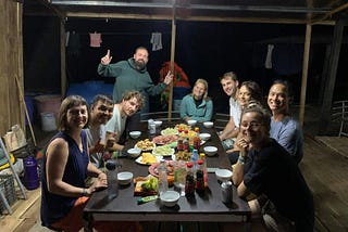 People at a table having dinner on a wooden floating house