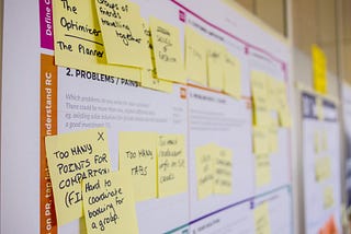 A close-up image of a board with sticky notes and other information, suggesting is taken from a UX workshop.