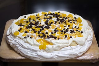 A delicious dessert of meringue topped with whipped cream and fruit. (This one has chocolate too —a step too far!)