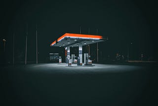 an empty filling station, surrounded by darkness