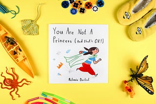 A children’s book surrounded by buttons, slippers and such