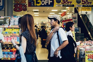 People walking past a discount store.