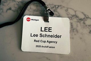 Lee Schneider’s ID badge from AIA Archifusion. White badge, black lettering with his name.