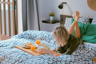 a sexy woman resting while enjoying breakfast in bed