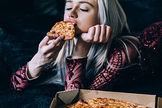 bored teenager eating pizza from a box