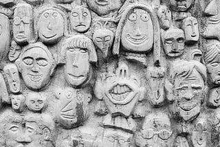 carved in stone many human faces expressing a verity on emotions
