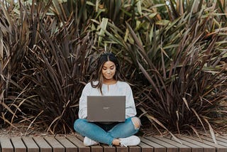 Woman sitting cross-legged and using a laptop.