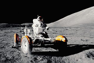 Astronaut driving a moon-buggy on the moon’s surface