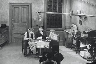 TV set of 1950s sitcom, The Honeymooners, showing main characters sitting around kitchen table in a very drab Brooklyn apartment
