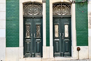 A pair of very similar front doors with ironwork