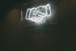 Neon sign of a handshake