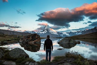 A man on a horizon of mountains.