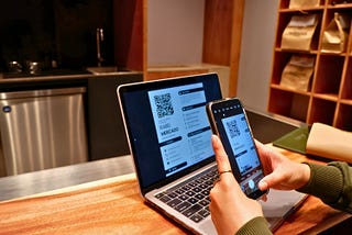 A person scanning a QR code from a resume to view an art portfolio.