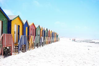 A line of colorful beach cabins.