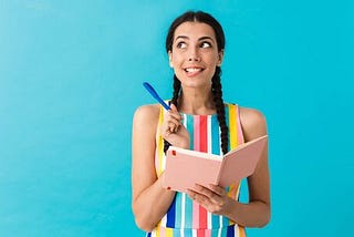 Woman with pencil in hand thinking about what to write in her journal