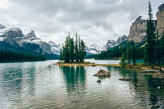 Mountain lake with trees and little island.