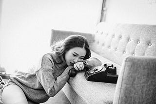 sad girl sitting beside the phone